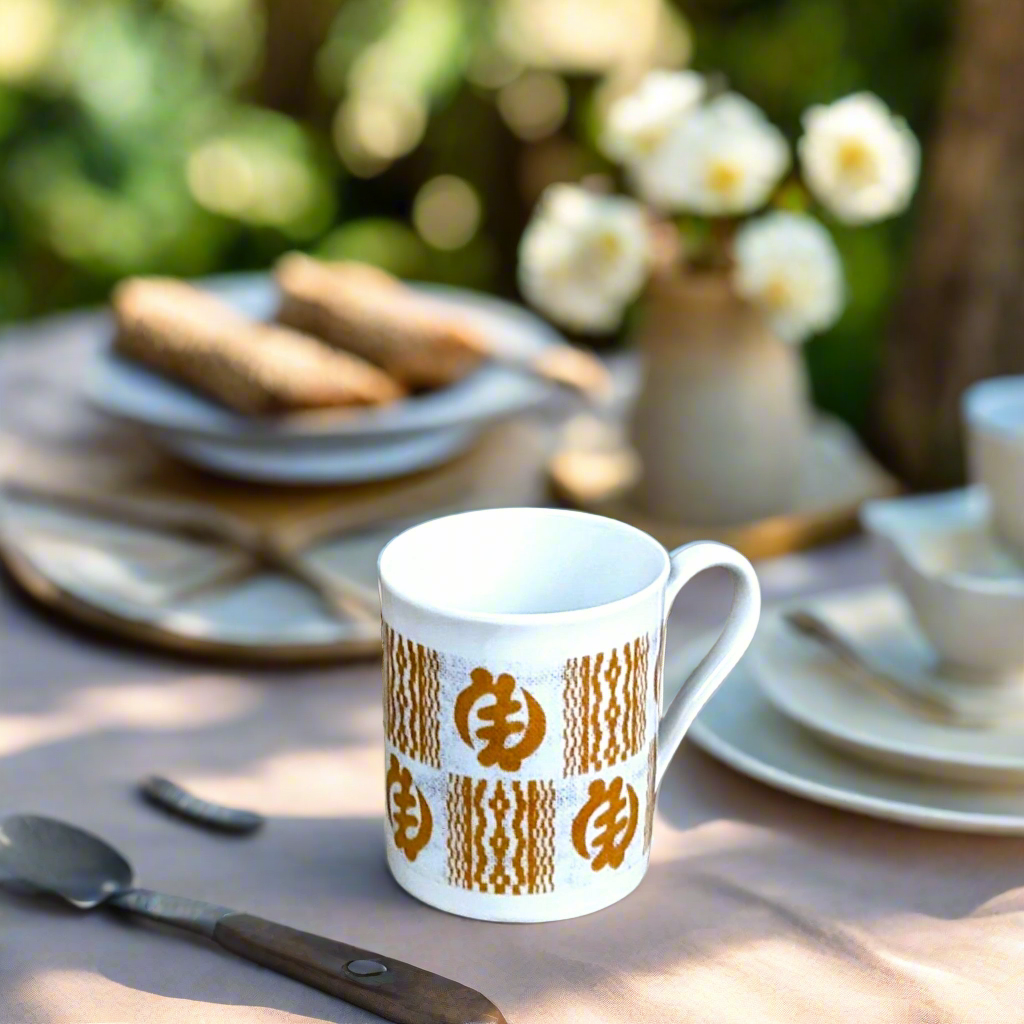 Coffret petit déjeuner en porcelaine fine française, orné d’un motif Ethnique "Adinkra" de Côte d'Ivoire, composé d'une petite assiette, d'un bol et d'un MUG, présentés dans une boîte prestige.