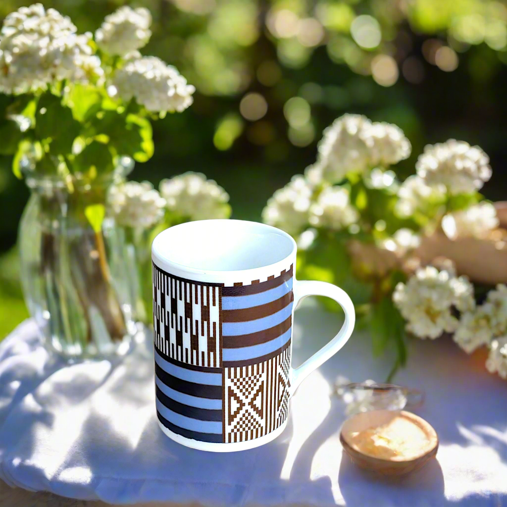 Coffret petit déjeuner en porcelaine fine française, orné d’un motif "Kanta" du Niger, composé d'une petite assiette, d'une tasse à café et d'un MUG, présentés dans une boîte prestige.