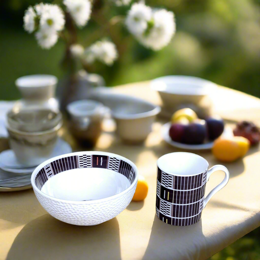 Coffret petit déjeuner en porcelaine fine française, orné d’un motif ethnique "Sénoufo" de Côte d'Ivoire, composé de 3 pièces parmi une petite assiette, d'un bol, une tasse à café et d'un MUG, présentés dans une boîte prestige.