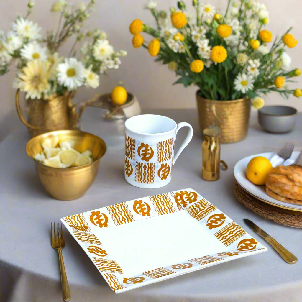Coffret petit déjeuner en porcelaine fine française, orné d’un motif Ethnique "Adinkra" de Côte d'Ivoire, composé d'une petite assiette, d'un bol et d'un MUG, présentés dans une boîte prestige.