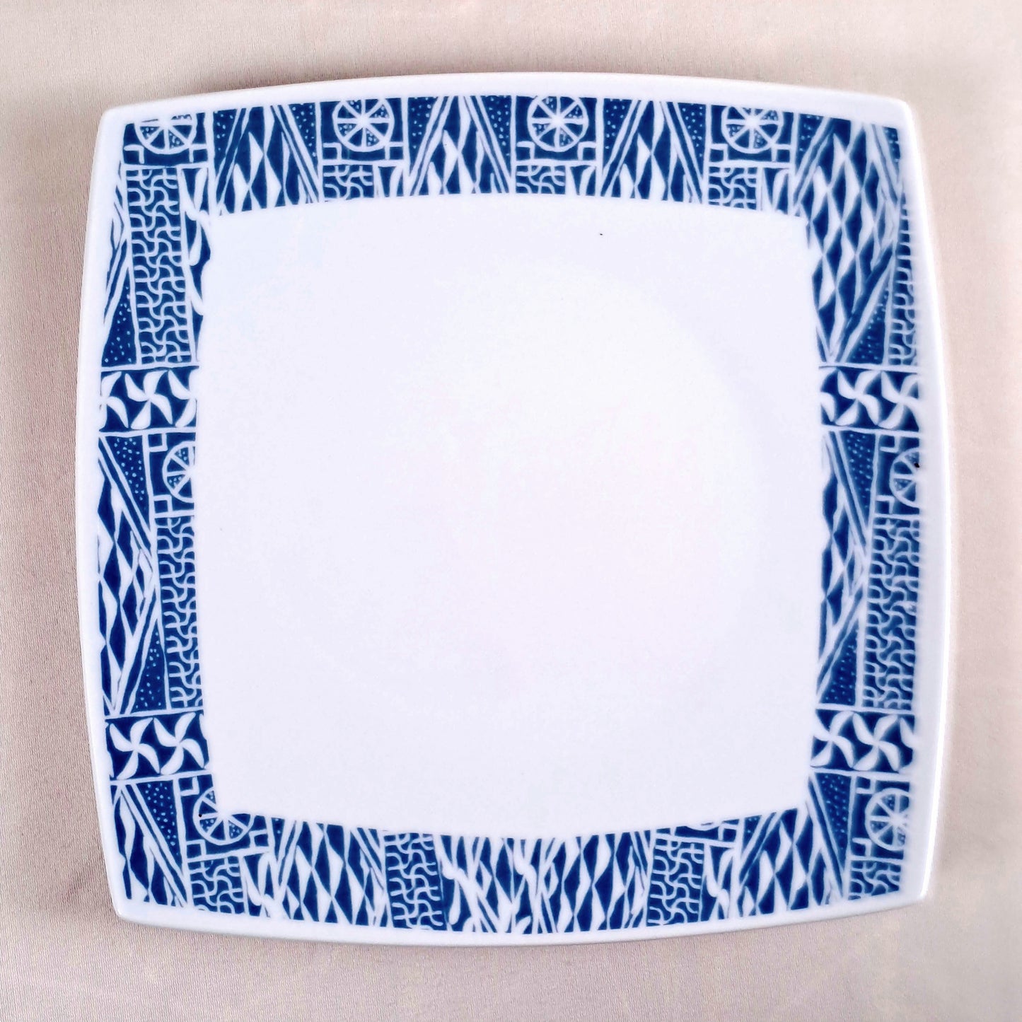 Coffret d'assiettes carrées en porcelaine fine Française fabriquées à la demande avec motif anneau ethnique d'Afrique "Ndop", du Cameroun présenté dans un coffret de 6 assiettes.