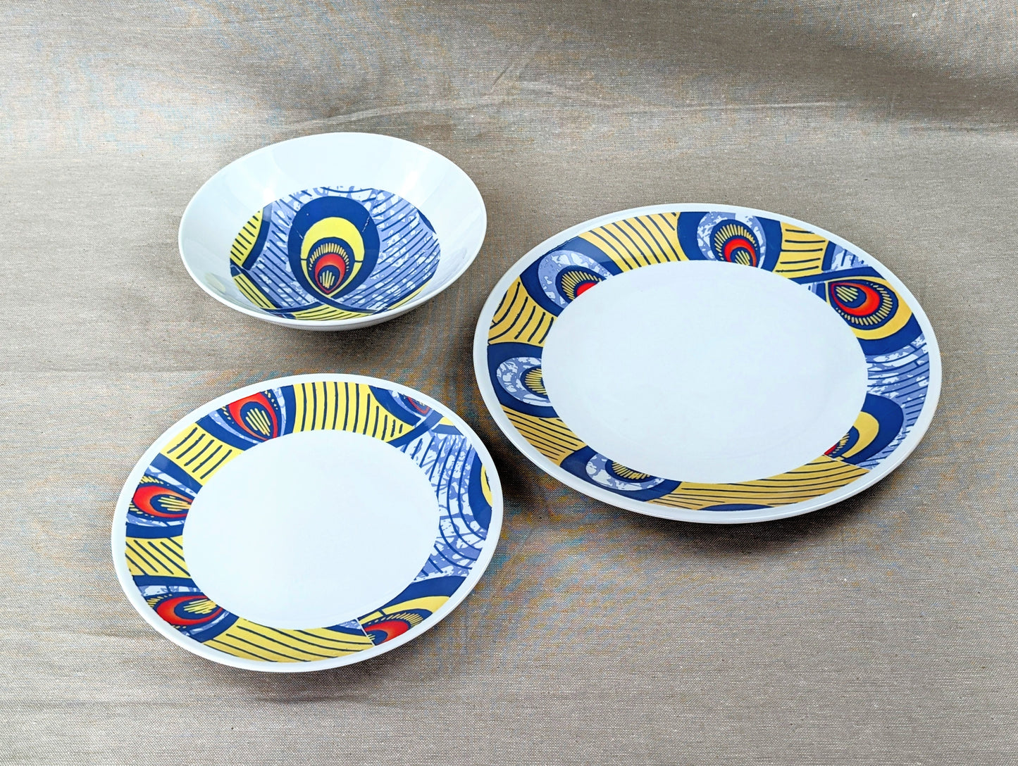 Coffret d'assiettes rondes en porcelaine fine Française fabriquées à la demande avec motif anneaux larges WAX d'afrique "Nos destins entrelacés" dans coffret de 6 assiettes.