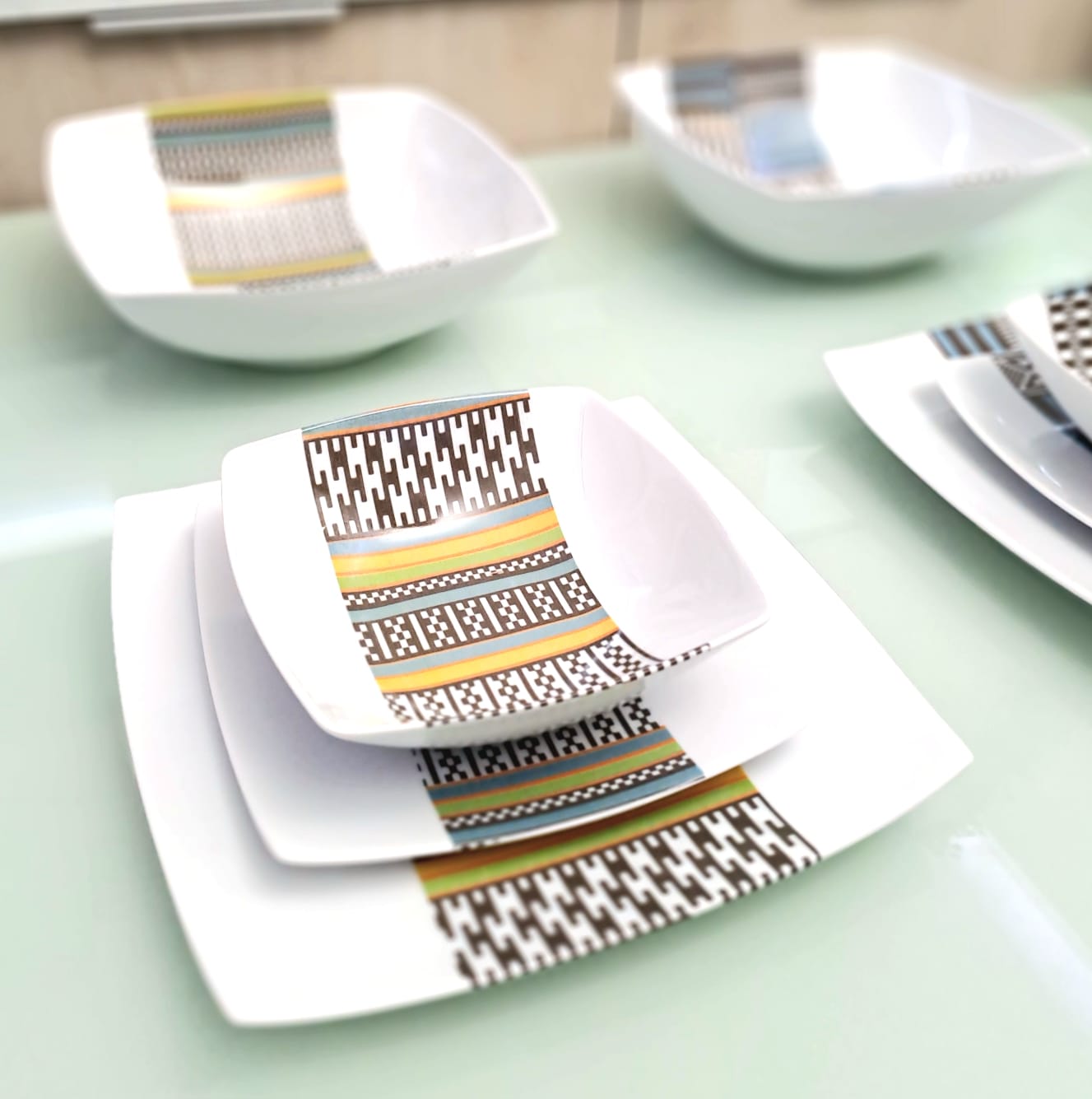 Coffret d'assiettes carrées en porcelaine fine Française fabriquées à la demande avec motif bande ethnique d'Afrique "Kounta" ou "Kanta" du Niger, présenté dans un coffret de 6 assiettes