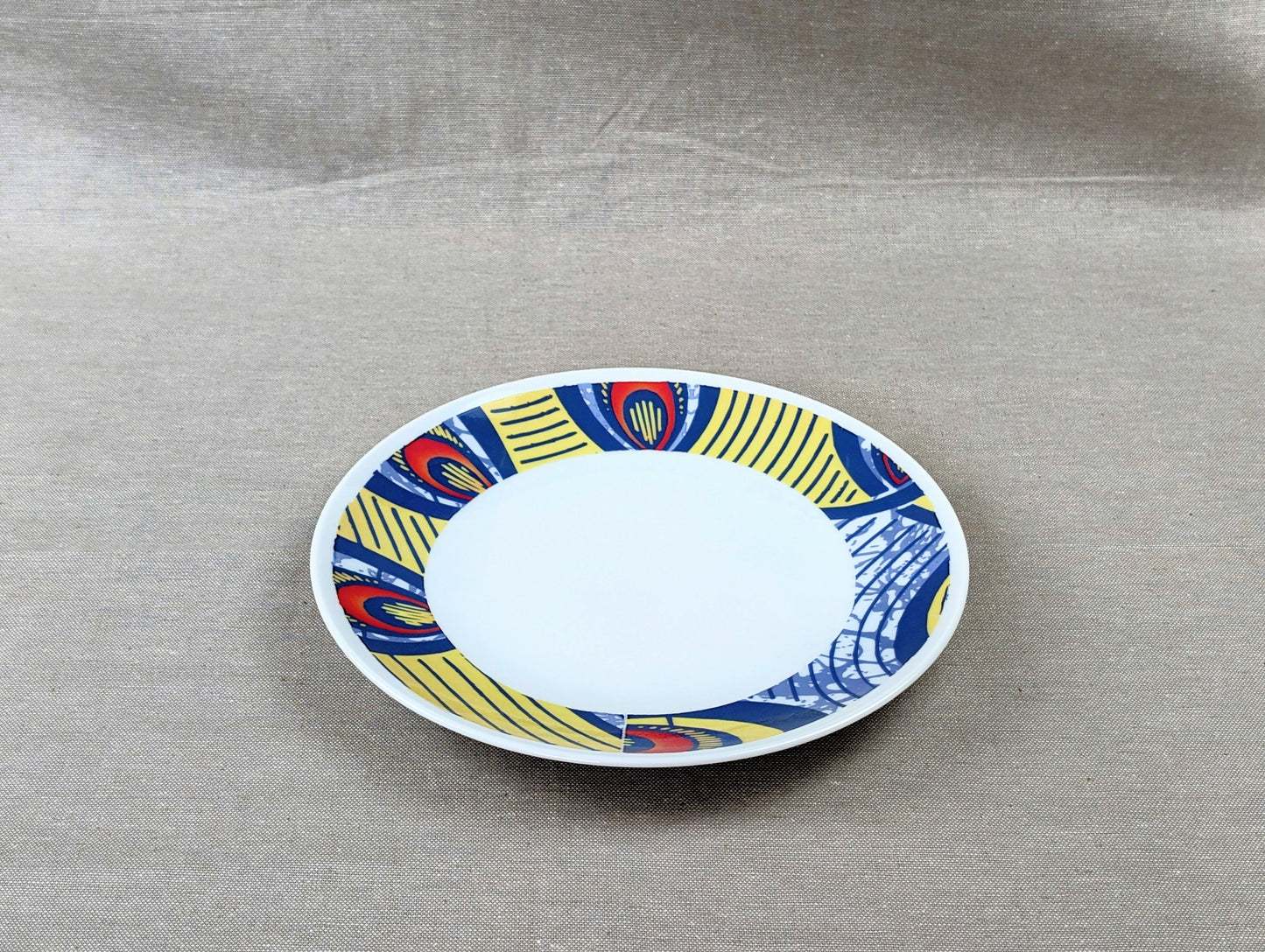 Coffret d'assiettes rondes en porcelaine fine Française fabriquées à la demande avec motif anneaux larges WAX d'afrique "Nos destins entrelacés" dans coffret de 6 assiettes.
