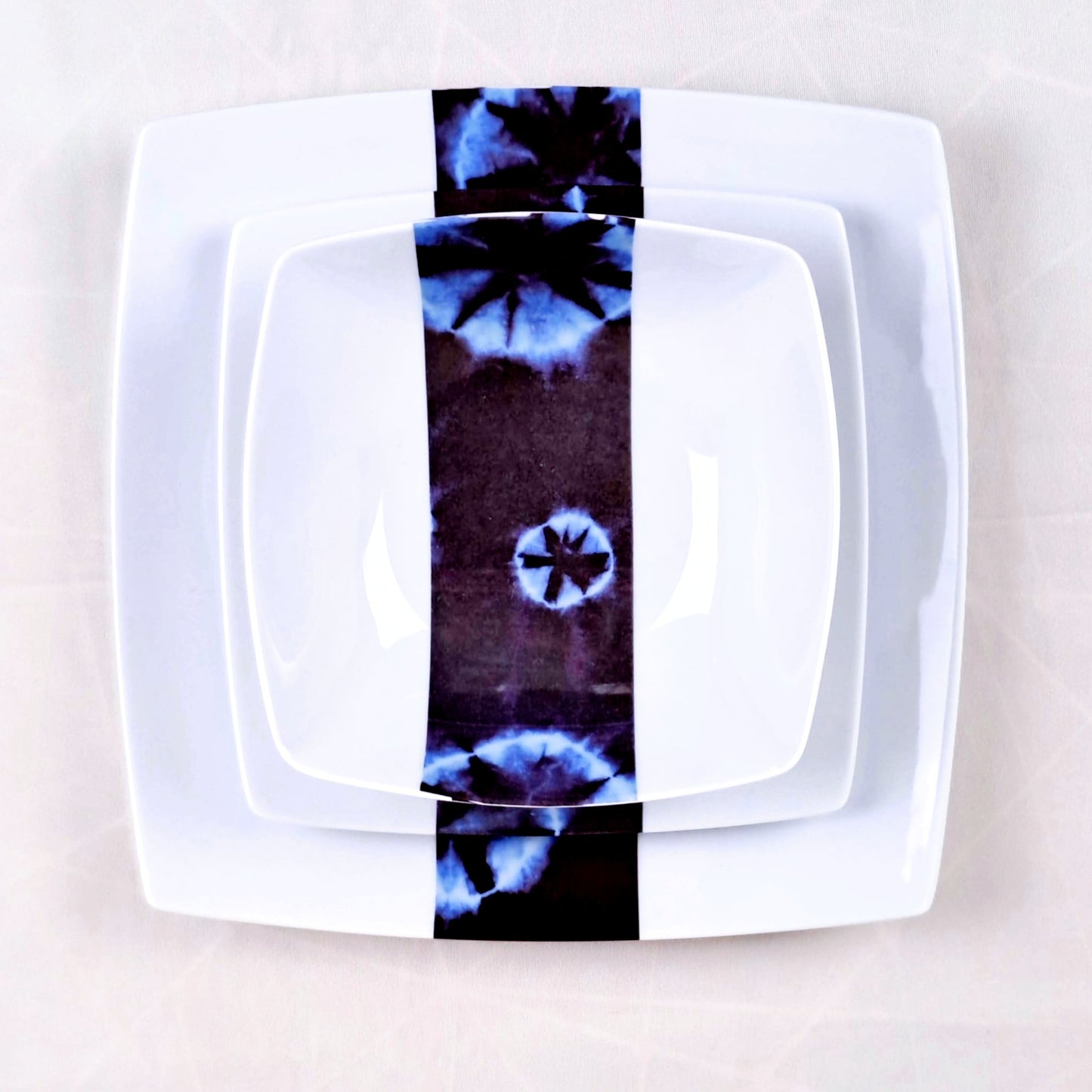 Coffret d'assiettes carrées en porcelaine fine Française fabriquées à la demande avec motif bande ethnique d'Afrique "Indigo bleu et noir" , présenté dans un coffret de 6 assiettes.