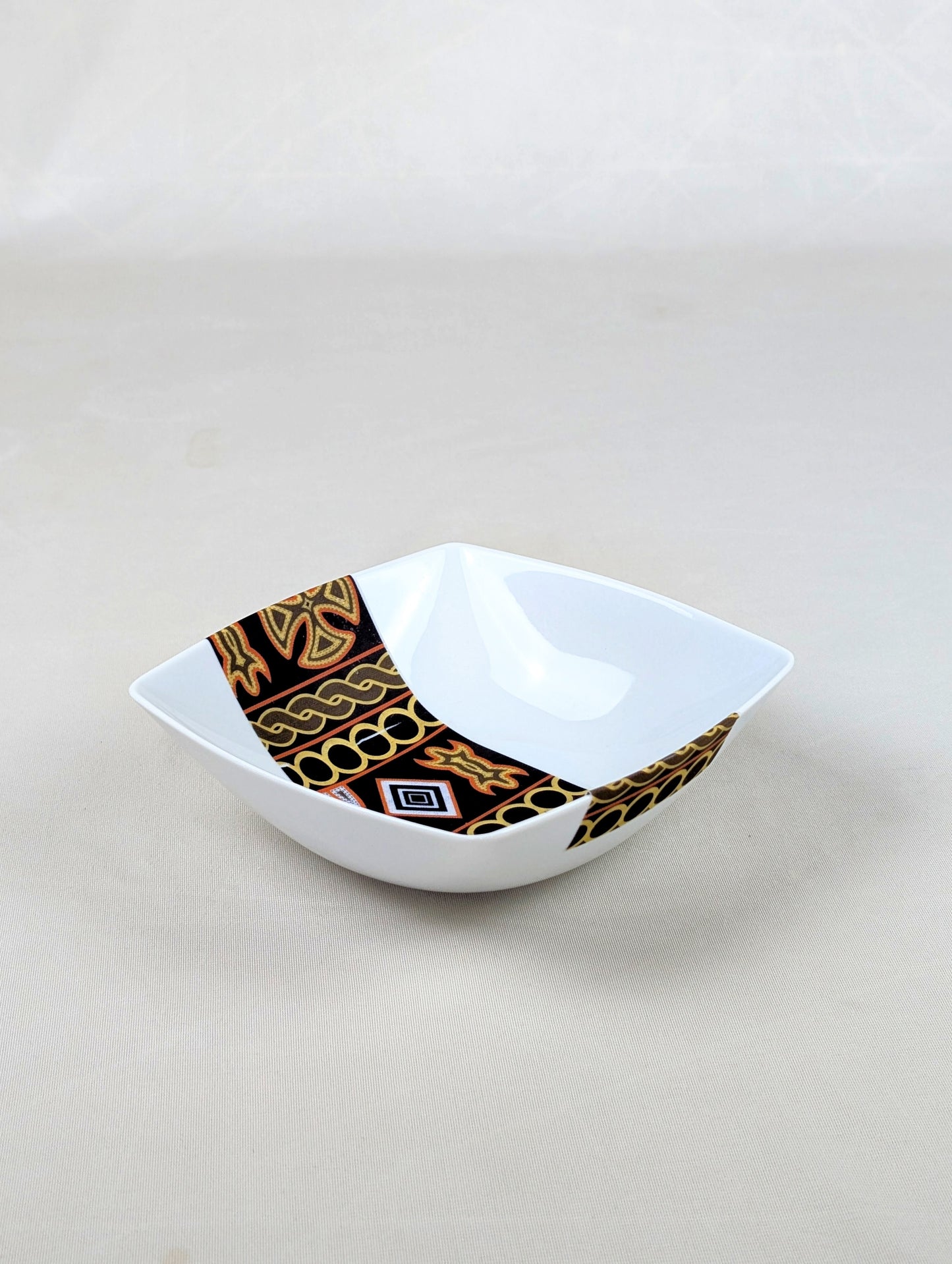 Coffret d'assiettes carrées en porcelaine fine Française fabriquées à la demande avec motif bande ethnique d'Afrique "Ndop" noir du Cameroun, présenté dans un coffret de 6 assiettes.