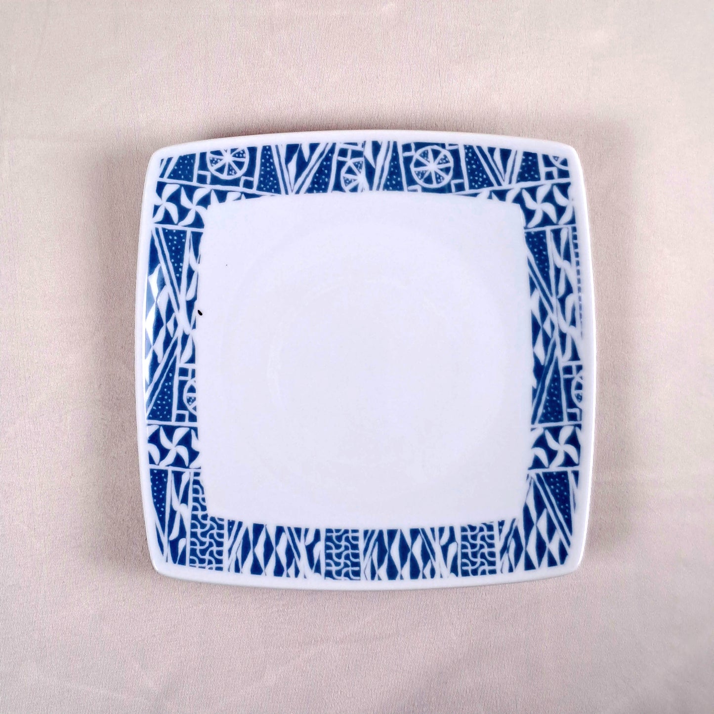 Coffret d'assiettes carrées en porcelaine fine Française fabriquées à la demande avec motif anneau ethnique d'Afrique "Ndop", du Cameroun présenté dans un coffret de 6 assiettes.