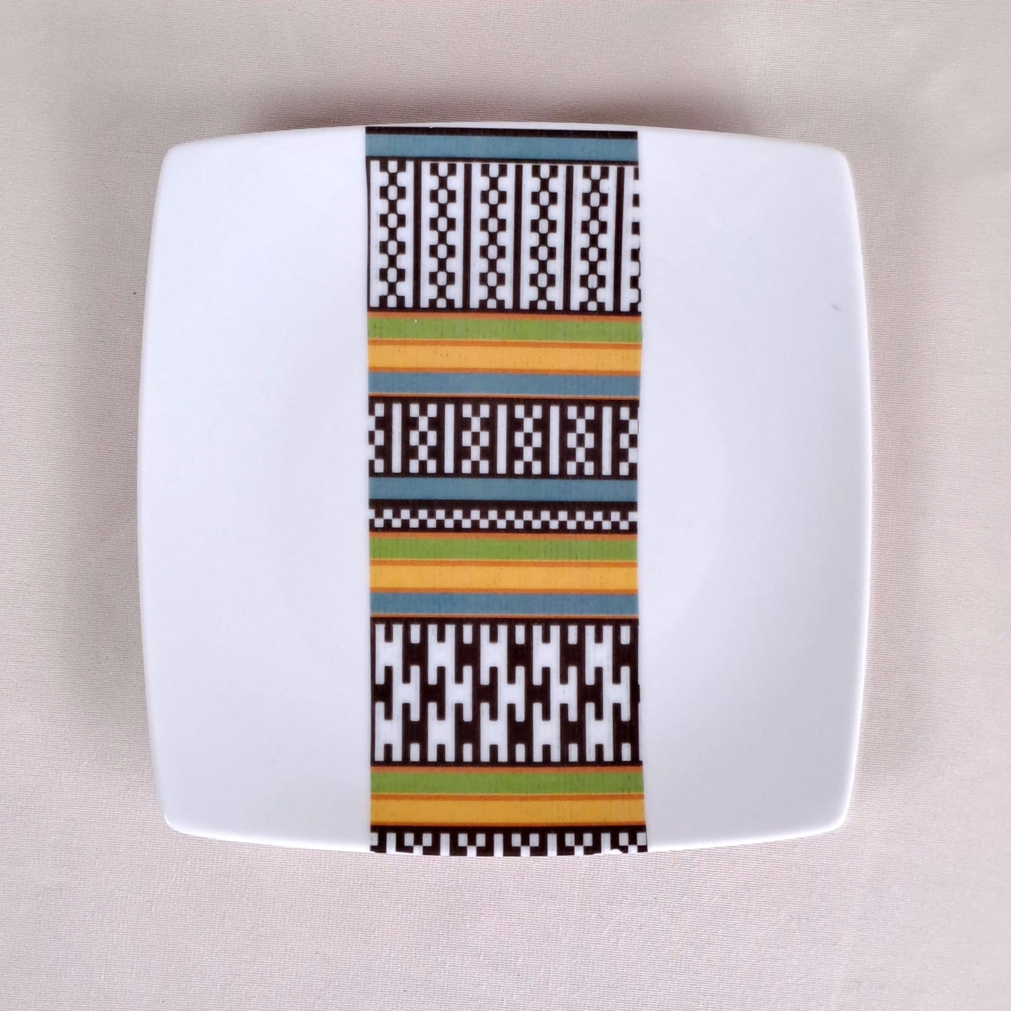 Coffret d'assiettes carrées en porcelaine fine Française fabriquées à la demande avec motif bande ethnique d'Afrique "Kounta" ou "Kanta" du Niger, présenté dans un coffret de 6 assiettes