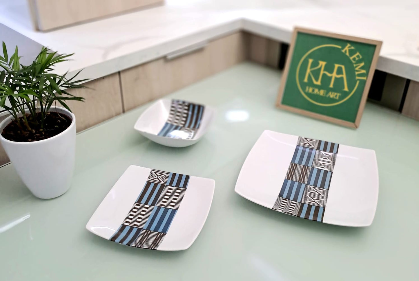 Coffret d'assiettes carrées en porcelaine fine Française fabriquées à la demande avec motif bande ethnique "Kounta" ou "Kanta" bleu du Niger, présenté dans un coffret de 6 assiettes