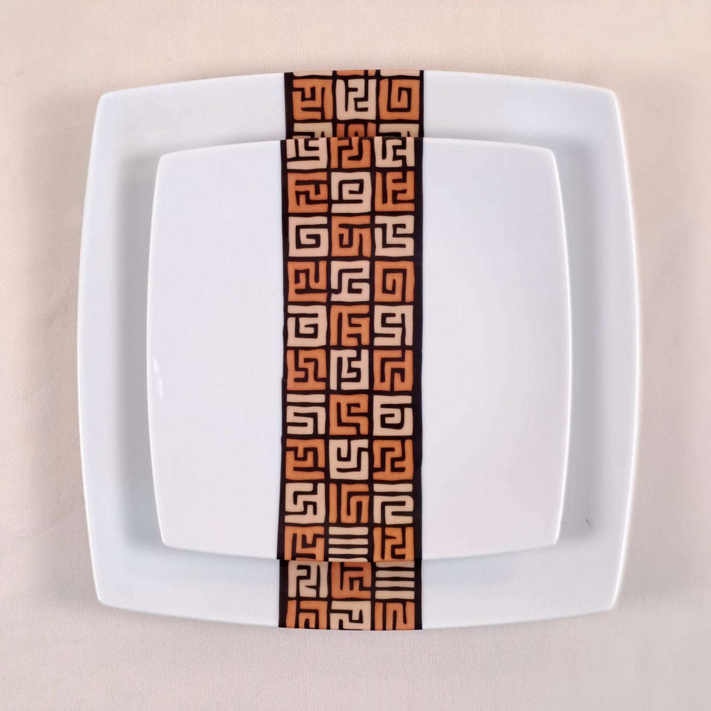 Coffret d'assiettes carrées en porcelaine fine Française fabriquées à la demande avec motif bande ethnique d'Afrique "#Ntshak (#N’tshak) du peuple Kuba ethnie shoowa du Congo, présenté dans un coffret de 6 assiettes.