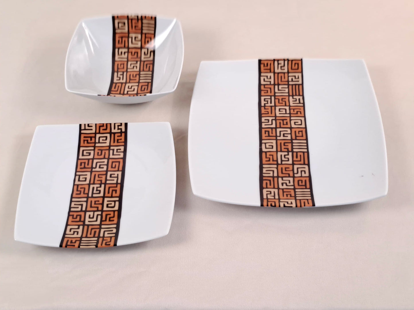 Coffret d'assiettes carrées en porcelaine fine Française fabriquées à la demande avec motif bande ethnique d'Afrique "#Ntshak (#N’tshak) du peuple Kuba ethnie shoowa du Congo, présenté dans un coffret de 6 assiettes.