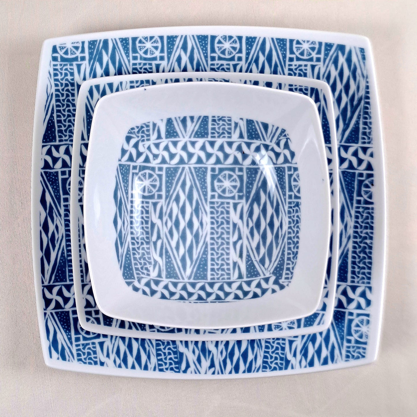 Coffret d'assiettes carrées en porcelaine fine Française fabriquées à la demande avec motif anneau ethnique d'Afrique "Ndop", du Cameroun présenté dans un coffret de 6 assiettes.