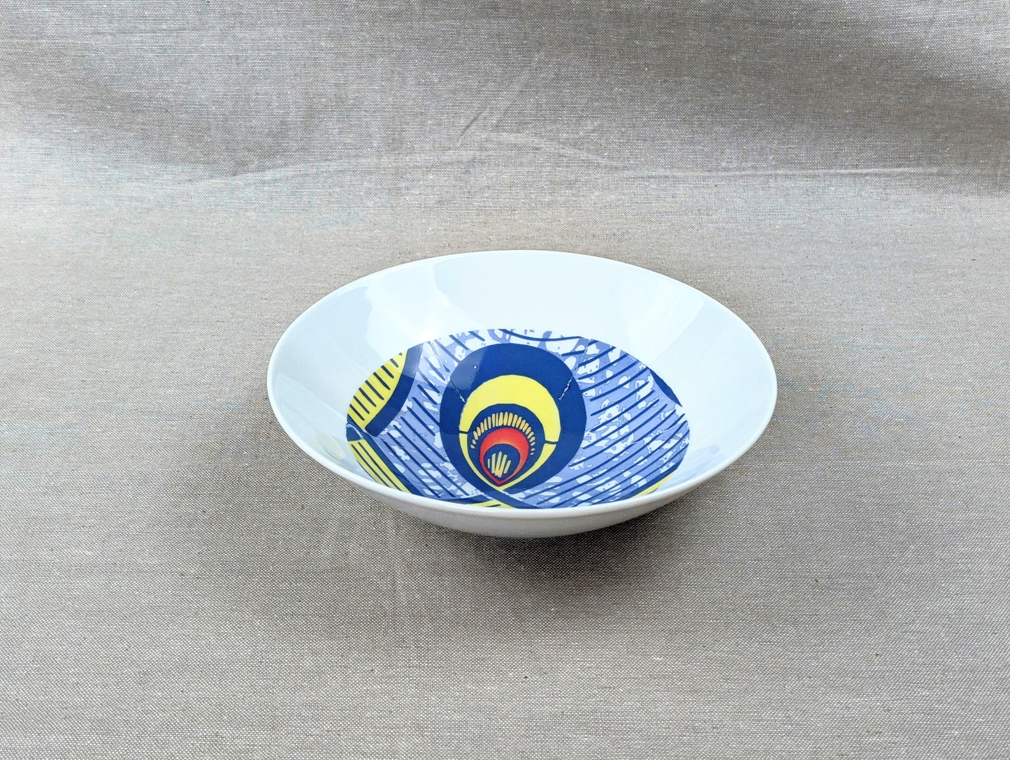 Coffret d'assiettes rondes en porcelaine fine Française fabriquées à la demande avec motif anneaux larges WAX d'afrique "Nos destins entrelacés" dans coffret de 6 assiettes.