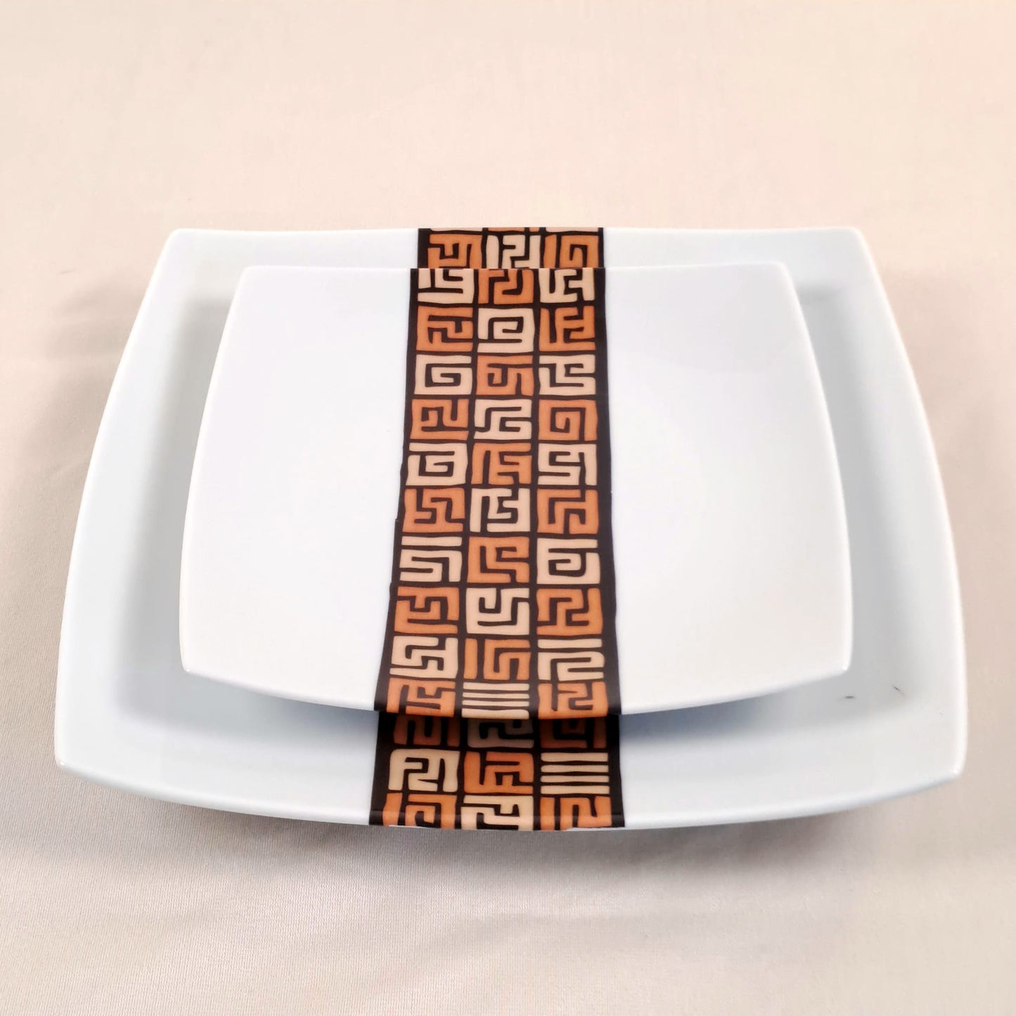 Coffret d'assiettes carrées en porcelaine fine Française fabriquées à la demande avec motif bande ethnique d'Afrique "#Ntshak (#N’tshak) du peuple Kuba ethnie shoowa du Congo, présenté dans un coffret de 6 assiettes.
