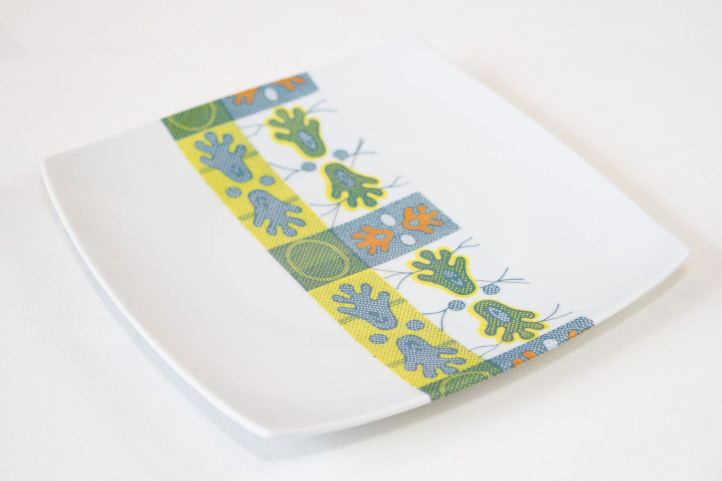 Coffret d'assiettes carrées en porcelaine fine Française fabriquées à la demande avec motif bande WAX d'afrique "Ton pied Mon pied" dans coffret de 12