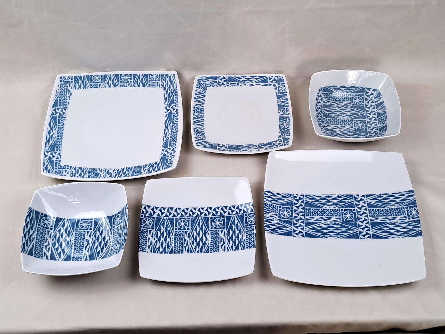 Coffret d'assiettes carrées en porcelaine fine Française fabriquées à la demande avec motif anneau ethnique d'Afrique "Ndop", du Cameroun présenté dans un coffret de 6 assiettes.