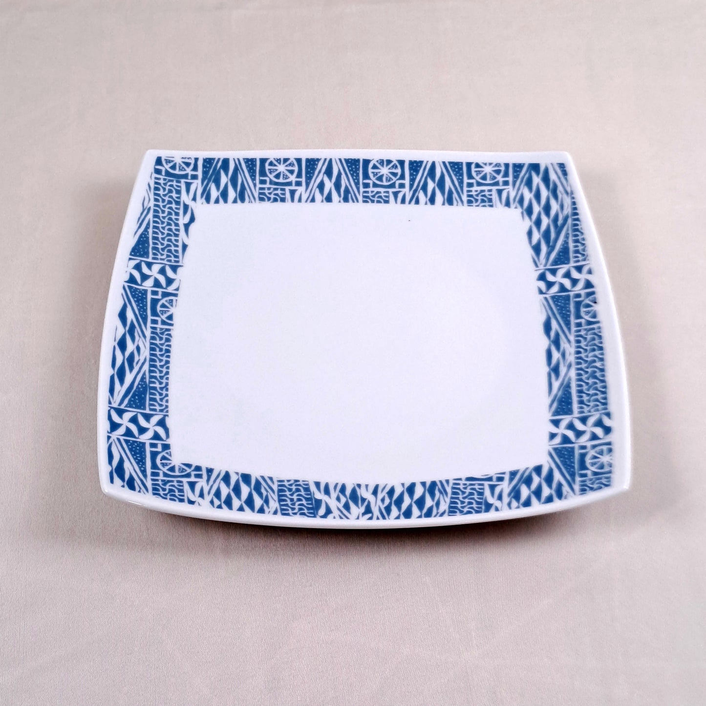 Coffret d'assiettes carrées en porcelaine fine Française fabriquées à la demande avec motif anneau ethnique d'Afrique "Ndop", du Cameroun présenté dans un coffret de 6 assiettes.