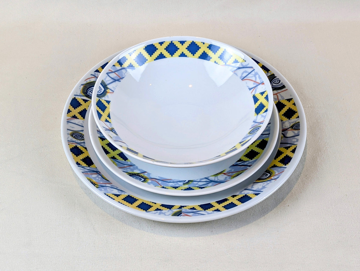 Coffret d'assiettes rondes en porcelaine fine Française fabriquées à la demande avec motif anneaux fins WAX d'afrique"Oeil de ma co-épouse" dans coffret de 6