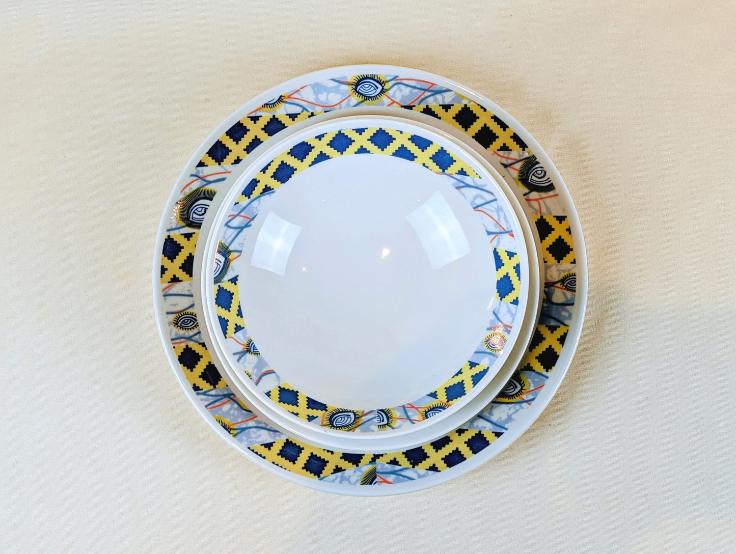 Coffret d'assiettes rondes en porcelaine fine Française fabriquées à la demande avec motif anneaux fins WAX d'afrique"Oeil de ma co-épouse" dans coffret de 6