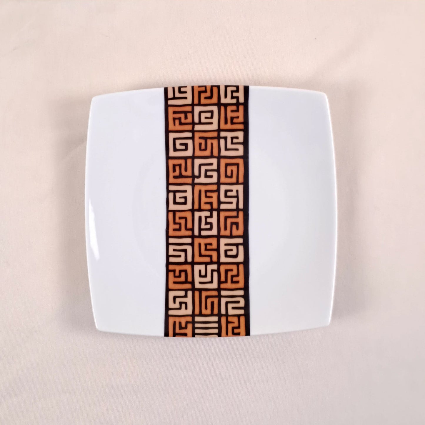 Coffret d'assiettes carrées en porcelaine fine Française fabriquées à la demande avec motif bande ethnique d'Afrique "#Ntshak (#N’tshak) du peuple Kuba ethnie shoowa du Congo, présenté dans un coffret de 6 assiettes.