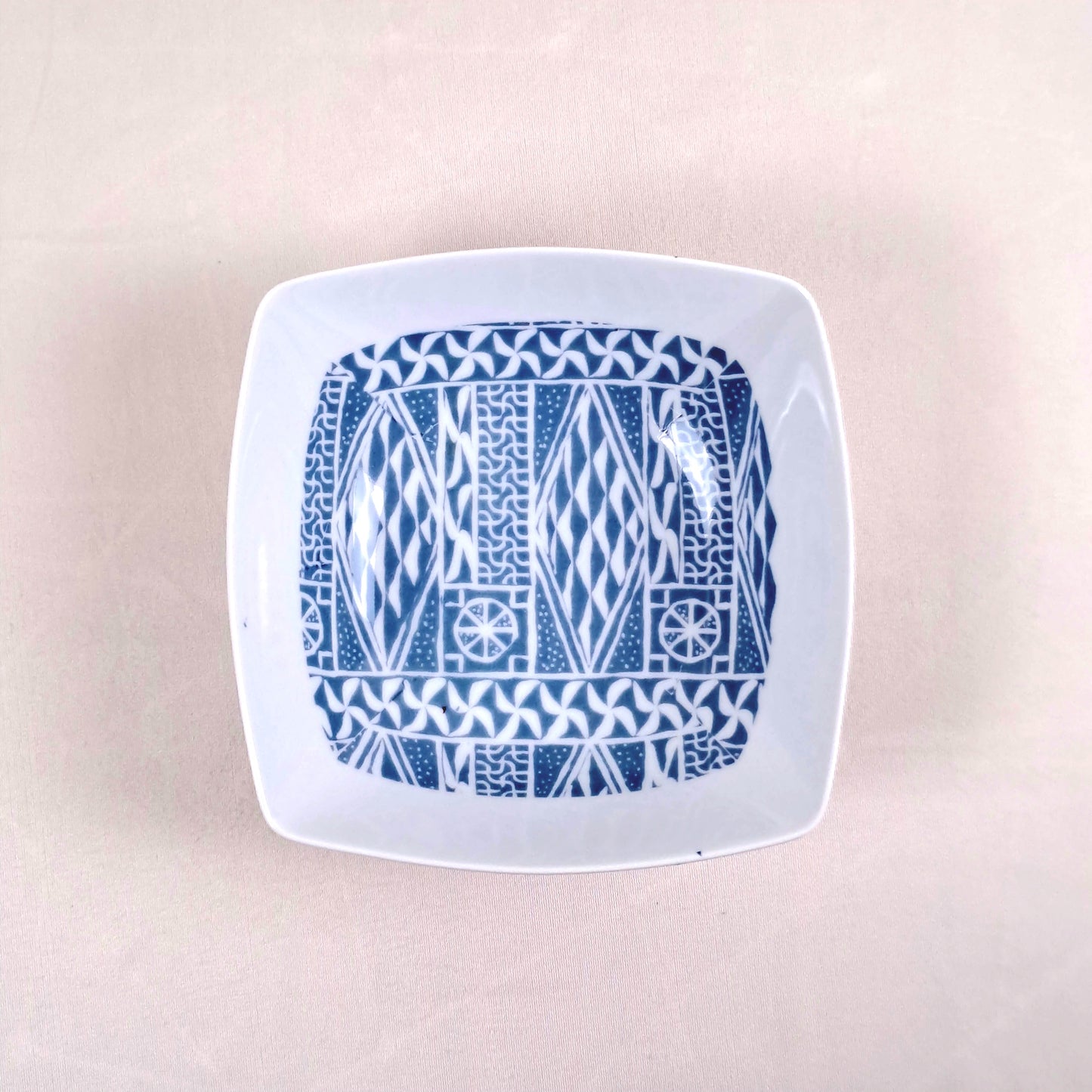 Coffret d'assiettes carrées en porcelaine fine Française fabriquées à la demande avec motif anneau ethnique d'Afrique "Ndop", du Cameroun présenté dans un coffret de 6 assiettes.