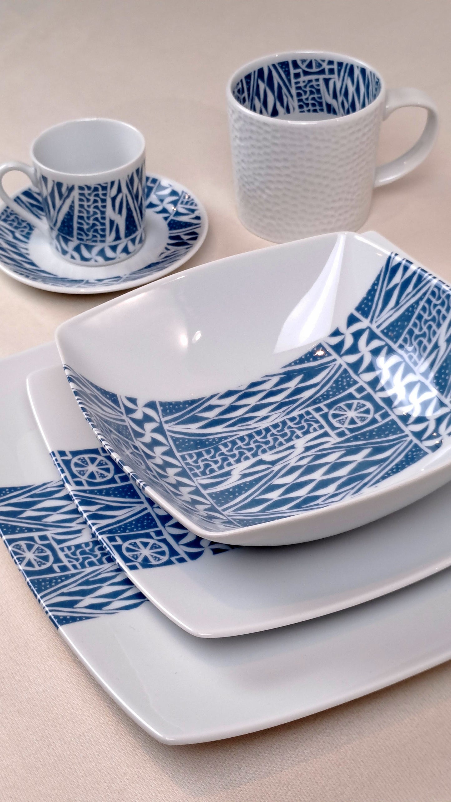 Coffret d'assiettes carrées en porcelaine fine Française fabriquées à la demande avec motif bande ethnique d'Afrique "Ndop" bleu du Cameroun, présenté dans un coffret de 6 assiettes.