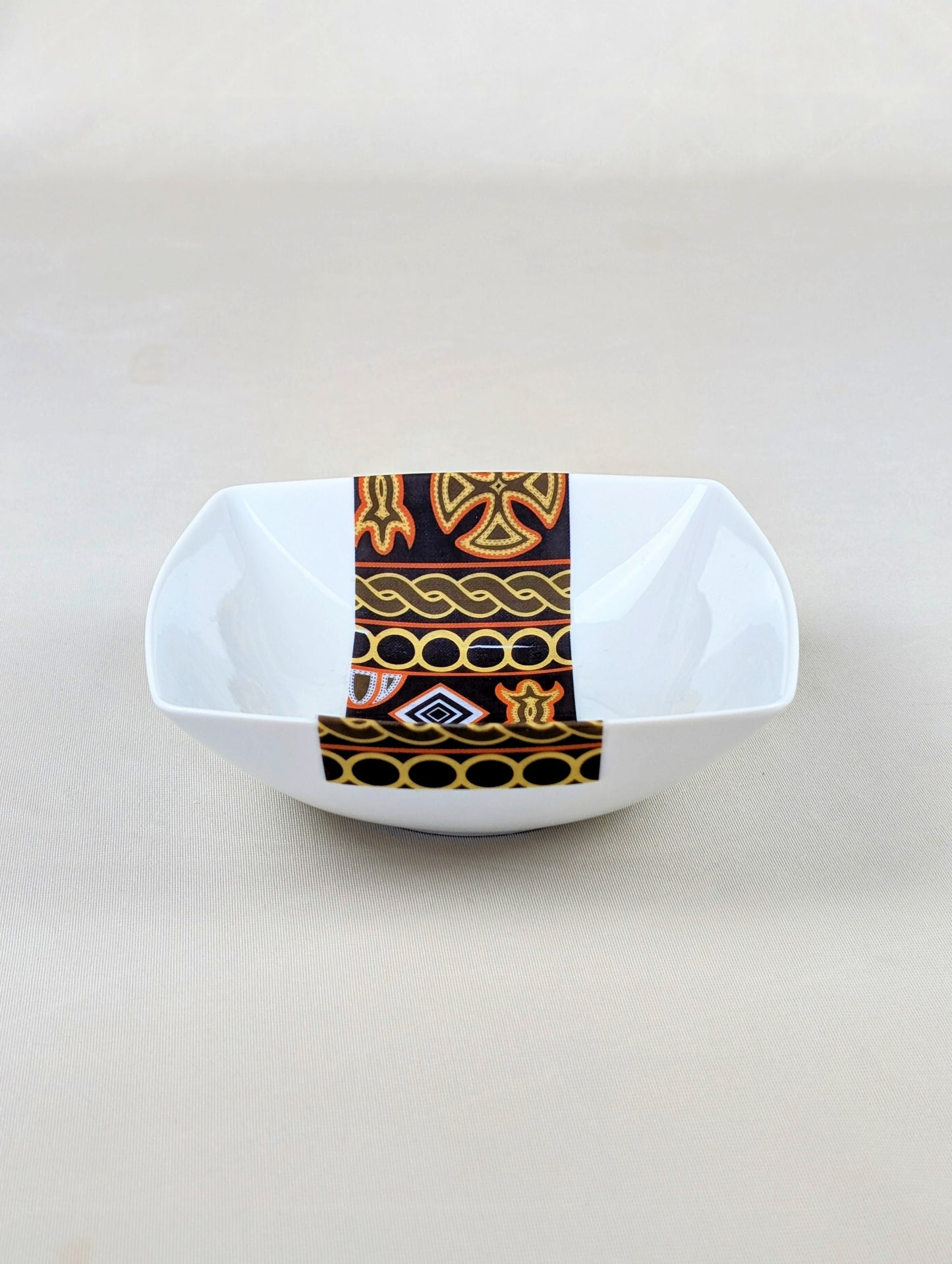 Coffret d'assiettes carrées en porcelaine fine Française fabriquées à la demande avec motif bande ethnique d'Afrique "Ndop" noir du Cameroun, présenté dans un coffret de 6 assiettes.
