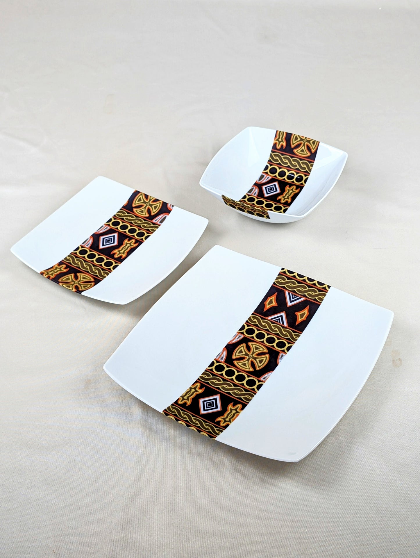 Coffret d'assiettes carrées en porcelaine fine Française fabriquées à la demande avec motif bande ethnique d'Afrique "Ndop" noir du Cameroun, présenté dans un coffret de 6 assiettes.