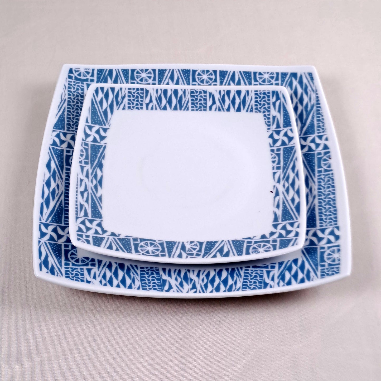 Coffret d'assiettes carrées en porcelaine fine Française fabriquées à la demande avec motif anneau ethnique d'Afrique "Ndop", du Cameroun présenté dans un coffret de 6 assiettes.