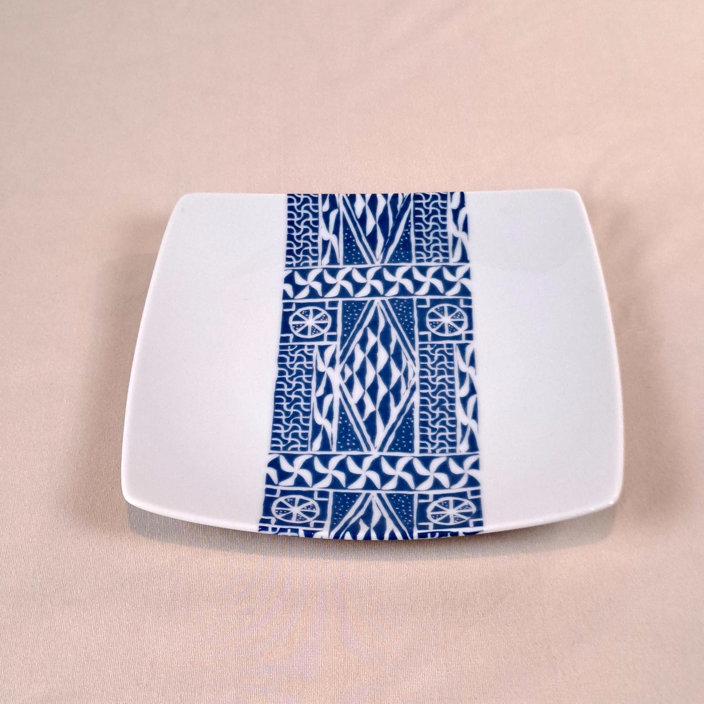 Coffret d'assiettes carrées en porcelaine fine Française fabriquées à la demande avec motif bande ethnique d'Afrique "Ndop" bleu du Cameroun, présenté dans un coffret de 6 assiettes.