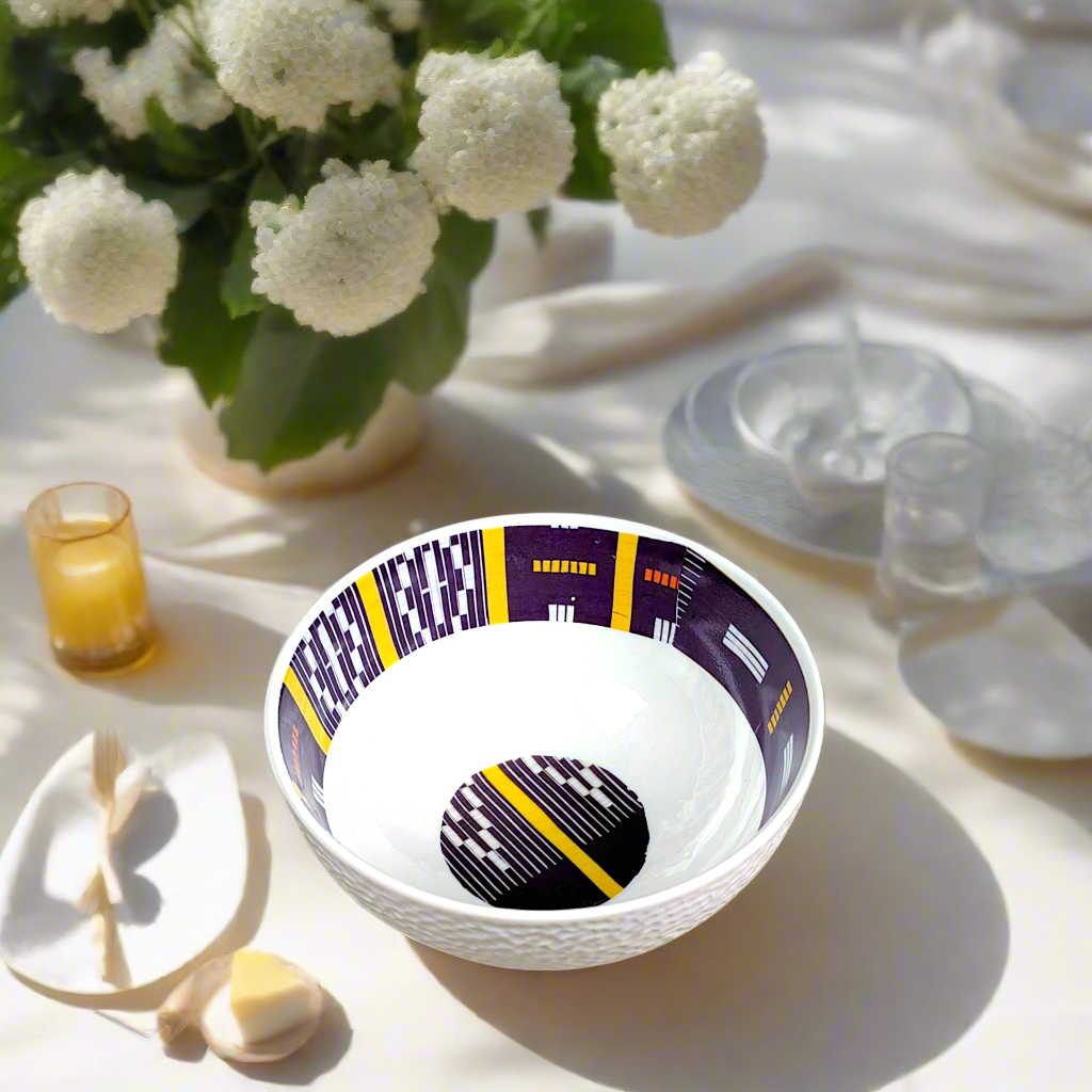 Coffret petit déjeuner en porcelaine fine française, orné d’un motif Baoulé de Côte d’Ivoire, composé d'une petite assiette, d'un grand bol et d'un MUG, présentés dans une boîte prestige.