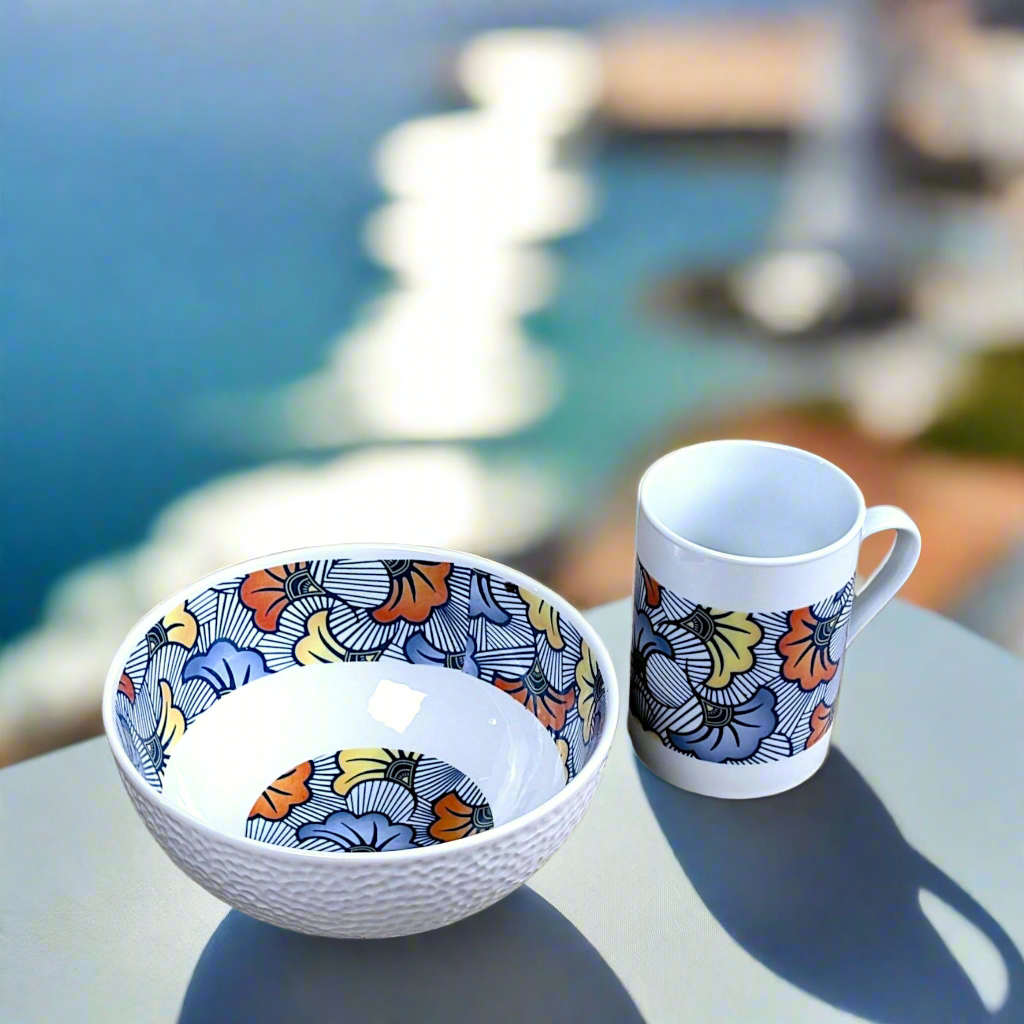 Coffret petit déjeuner en porcelaine fine française, orné d’un motif WAX "Fleurs de Mariage" bleu, composé d'une petite assiette, d'un bol et d'un MUG, présentés dans une boîte prestige.