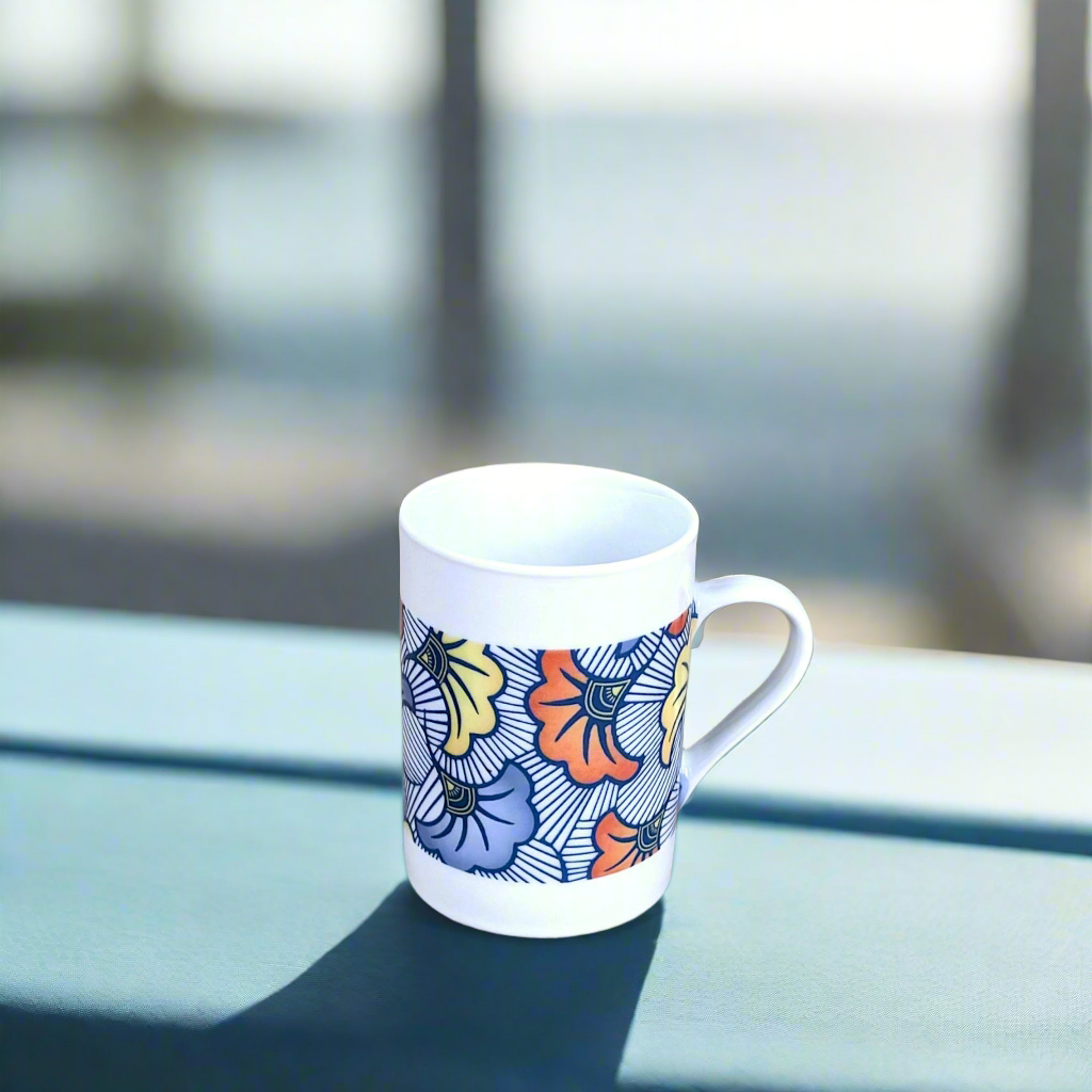 Coffret petit déjeuner en porcelaine fine française, orné d’un motif WAX "Fleurs de Mariage" bleu, composé d'une petite assiette, d'un bol et d'un MUG, présentés dans une boîte prestige.