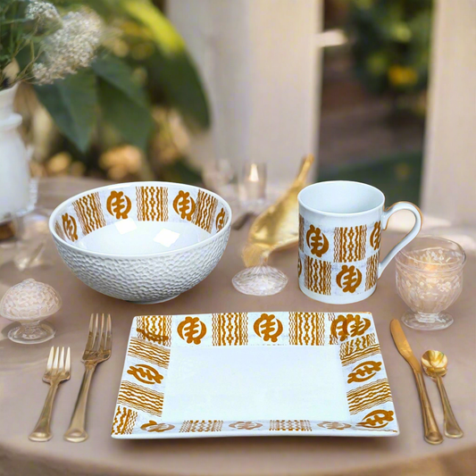 Coffret petit déjeuner en porcelaine fine française, orné d’un motif Ethnique "Adinkra" de Côte d'Ivoire, composé d'une petite assiette, d'un bol et d'un MUG, présentés dans une boîte prestige.