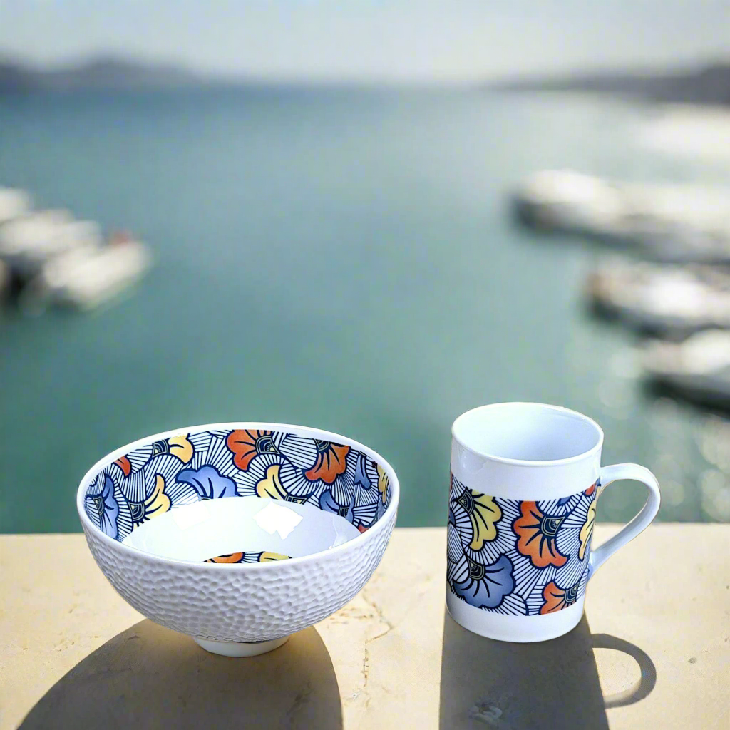 Coffret petit déjeuner en porcelaine fine française, orné d’un motif WAX "Fleurs de Mariage" bleu, composé d'une petite assiette, d'un bol et d'un MUG, présentés dans une boîte prestige.