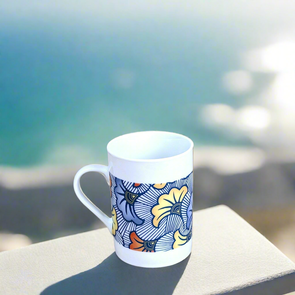 Coffret petit déjeuner en porcelaine fine française, orné d’un motif WAX "Fleurs de Mariage" bleu, composé d'une petite assiette, d'un bol et d'un MUG, présentés dans une boîte prestige.