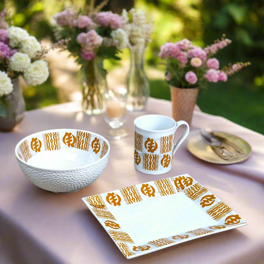 Coffret petit déjeuner en porcelaine fine française, orné d’un motif Ethnique "Adinkra" de Côte d'Ivoire, composé d'une petite assiette, d'un bol et d'un MUG, présentés dans une boîte prestige.