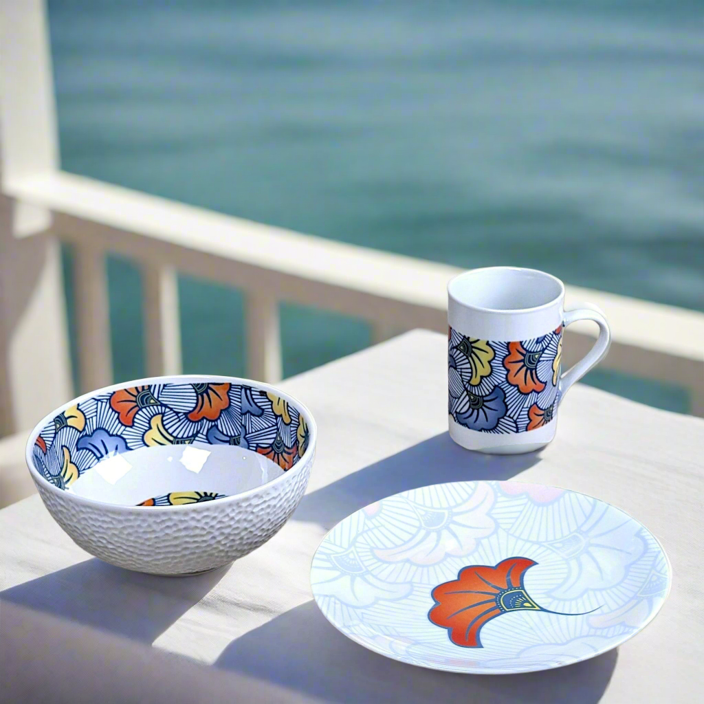 Coffret petit déjeuner en porcelaine fine française, orné d’un motif WAX "Fleurs de Mariage" bleu, composé d'une petite assiette, d'un bol et d'un MUG, présentés dans une boîte prestige.