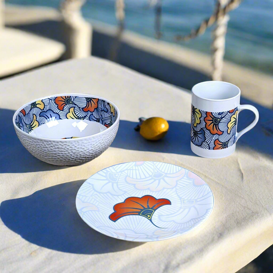 Coffret petit déjeuner en porcelaine fine française, orné d’un motif WAX "Fleurs de Mariage" bleu, composé d'une petite assiette, d'un bol et d'un MUG, présentés dans une boîte prestige.