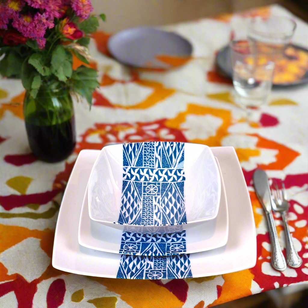 Coffret d'assiettes carrées en porcelaine fine Française fabriquées à la demande avec motif bande ethnique d'Afrique "Ndop" bleu du Cameroun, présenté dans un coffret de 6 assiettes.