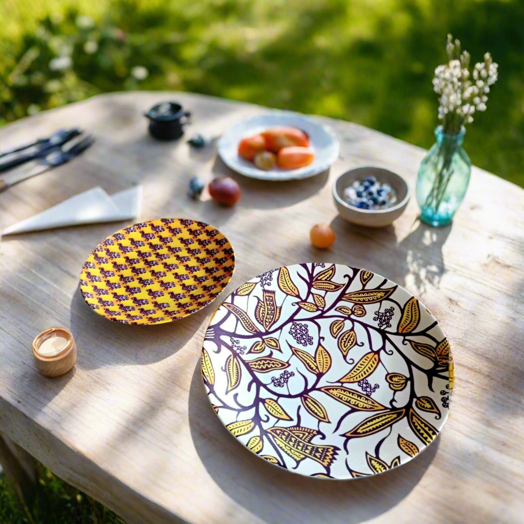 Vue plongeante en jardin : assiettes rondes Makaïva sur table en bois, fruits, myrtilles et vase fleuri