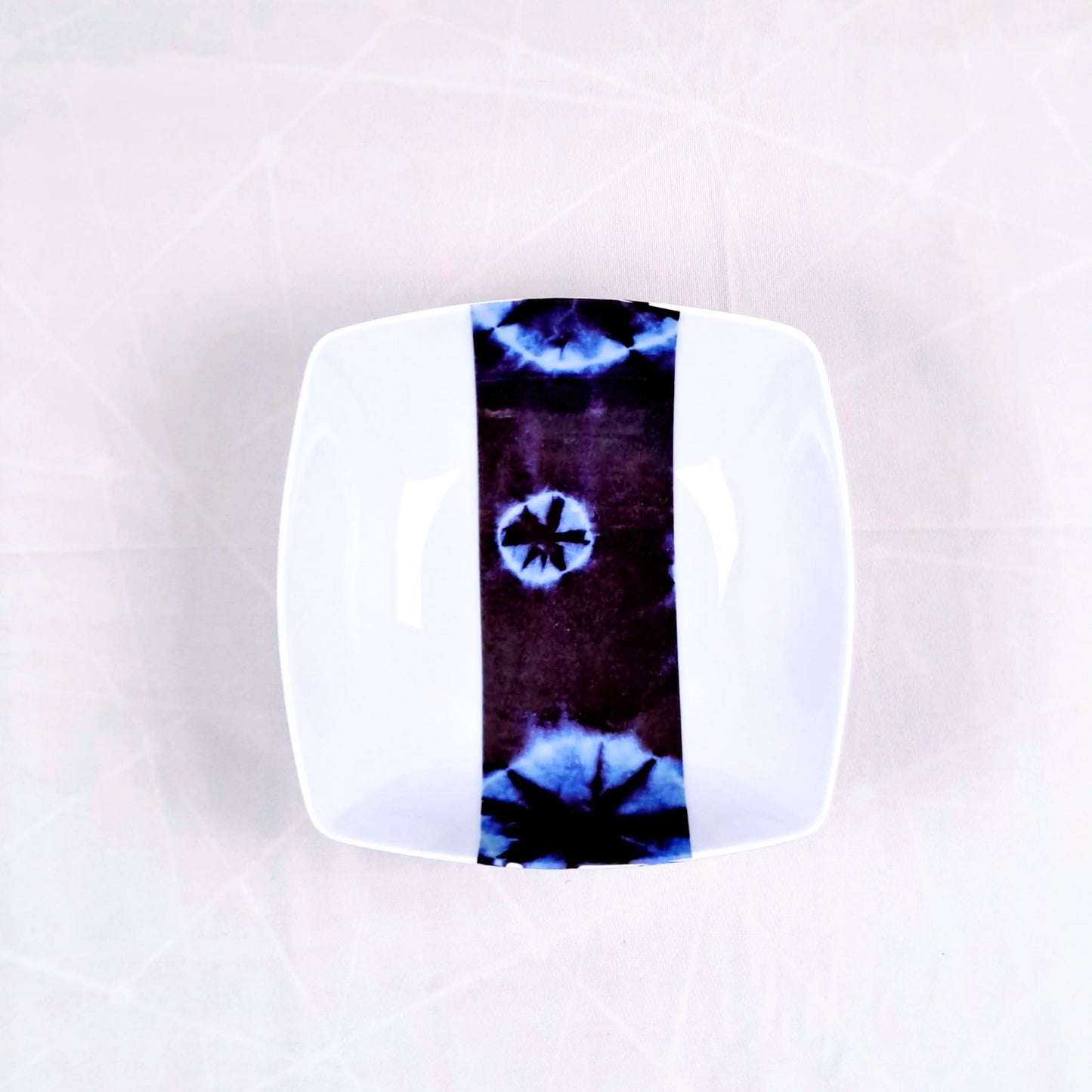Coffret d'assiettes carrées en porcelaine fine Française fabriquées à la demande avec motif bande ethnique d'Afrique "Indigo bleu et noir" , présenté dans un coffret de 6 assiettes.