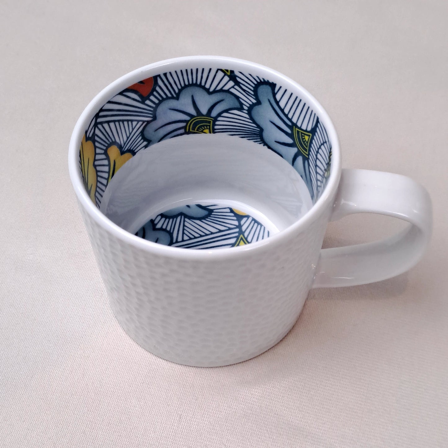 Mug en porcelaine fine Française grenaillé à l'extérieur, motif wax d'Afrique "Fleurs de Mariage" à l'intérieur