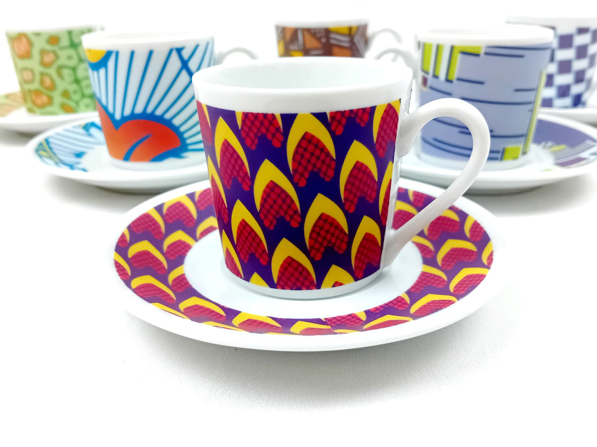 Plan rapproché de trois quarts : tasse à café Ongles de Marie-Thérèse sur soucoupe, autres tasses wax en fond blanc