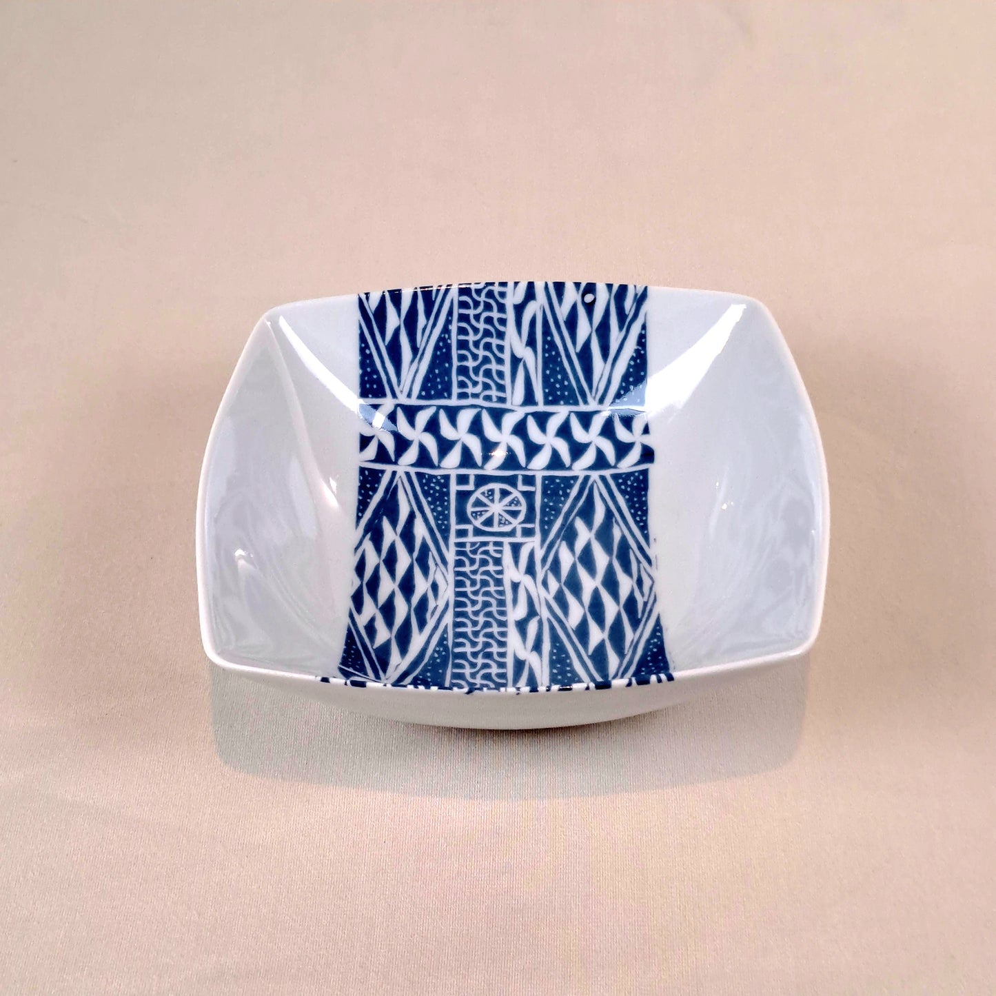 Coffret d'assiettes carrées en porcelaine fine Française fabriquées à la demande avec motif bande ethnique d'Afrique "Ndop" bleu du Cameroun, présenté dans un coffret de 6 assiettes.