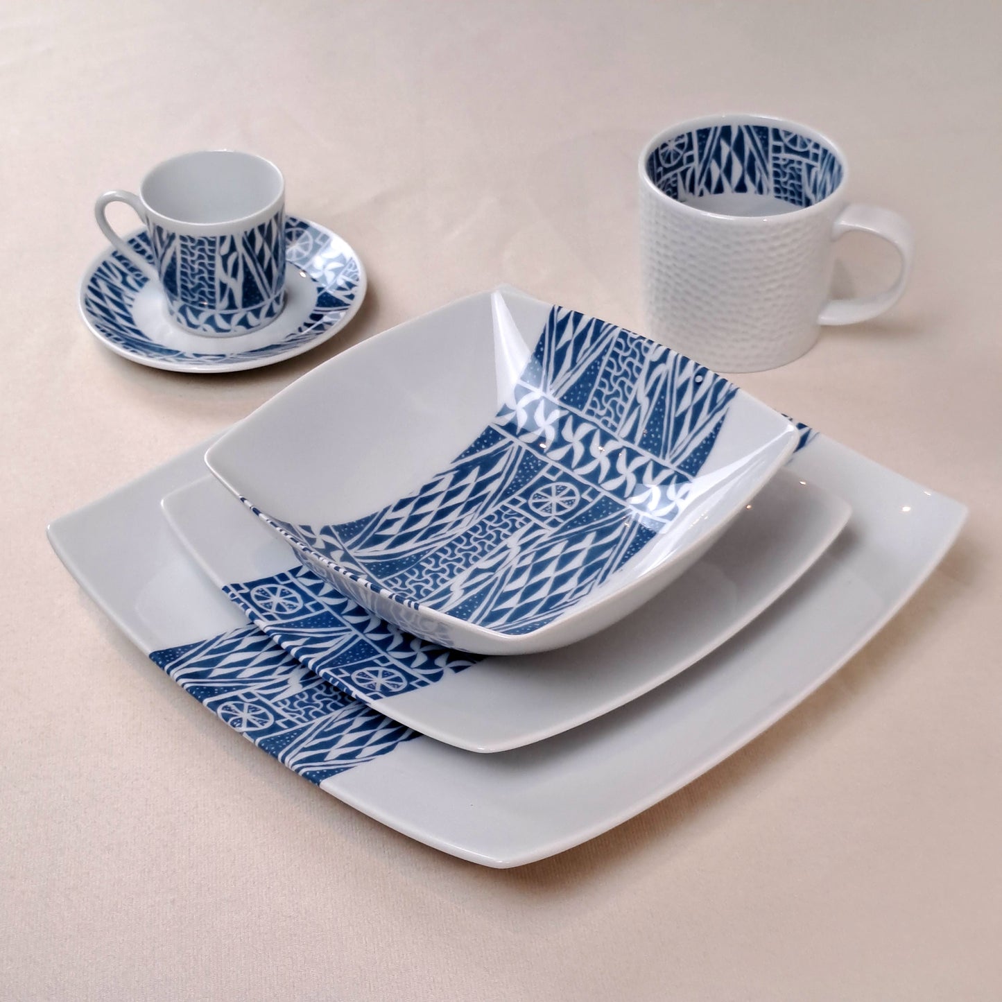 Coffret d'assiettes carrées en porcelaine fine Française fabriquées à la demande avec motif bande ethnique d'Afrique "Ndop" bleu du Cameroun, présenté dans un coffret de 6 assiettes.