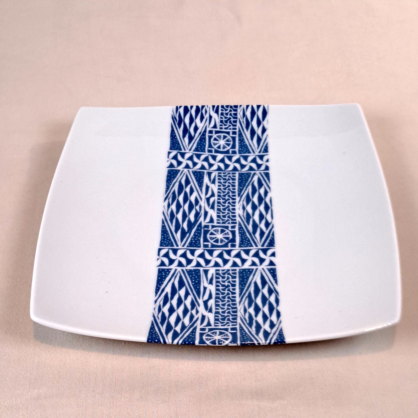 Coffret d'assiettes carrées en porcelaine fine Française fabriquées à la demande avec motif bande ethnique d'Afrique "Ndop" bleu du Cameroun, présenté dans un coffret de 6 assiettes.