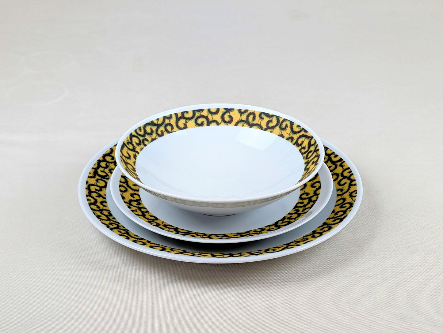 Coffret d'assiettes rondes en porcelaine fine Française fabriquées à la demande avec motif anneaux fins WAX d'afrique "Macaroni ou Conseiller" jaune dans coffret de 6 assiettes.