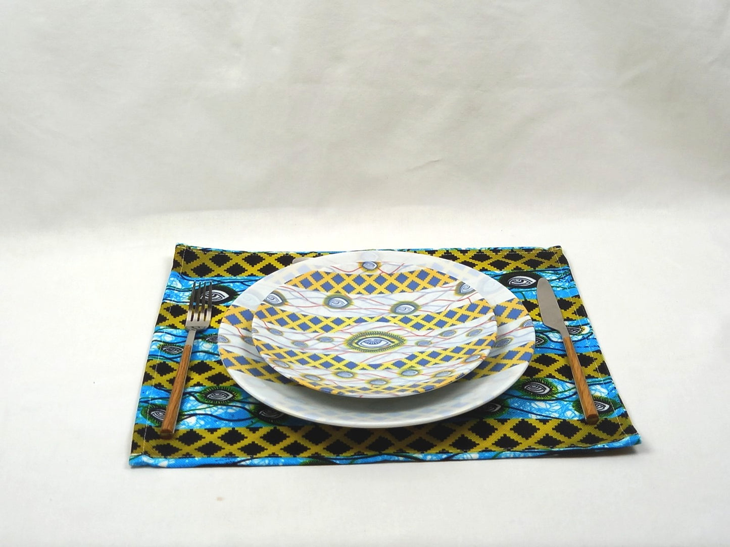 Coffret d'assiettes rondes en porcelaine fine Française fabriquées à la demande avec  motif plein WAX d'afrique "Oeil de ma co-épouse" dans coffret de 6