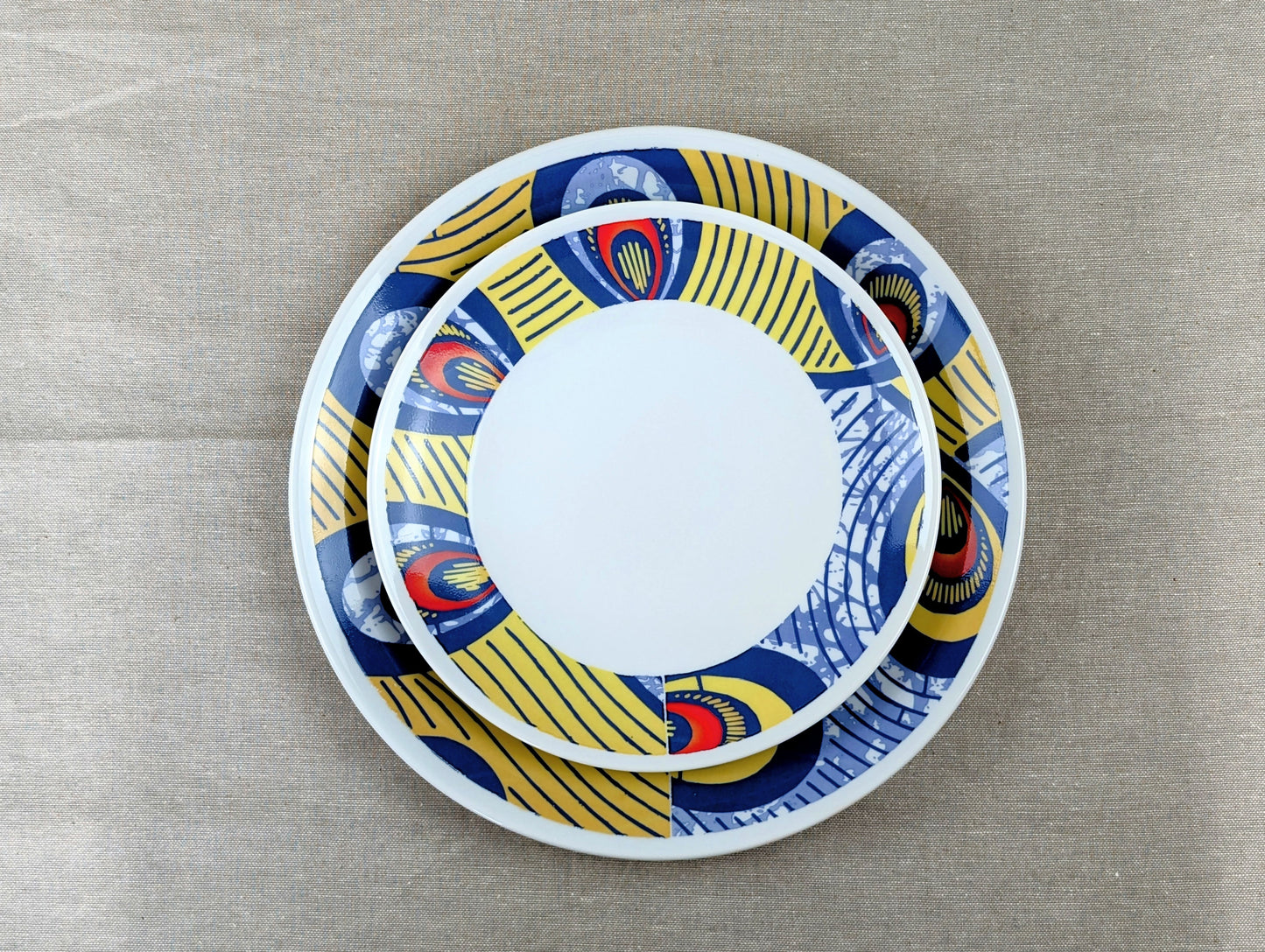 Coffret d'assiettes rondes en porcelaine fine Française fabriquées à la demande avec motif anneaux larges WAX d'afrique "Nos destins entrelacés" dans coffret de 6 assiettes.